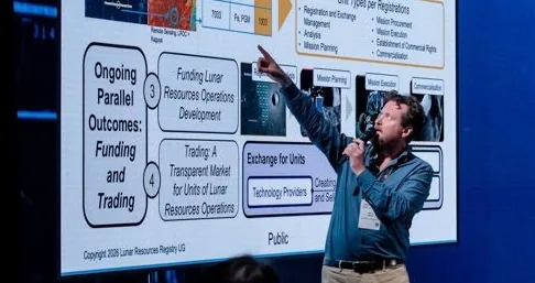 Simon Drake on a stage in front of a presentation slide